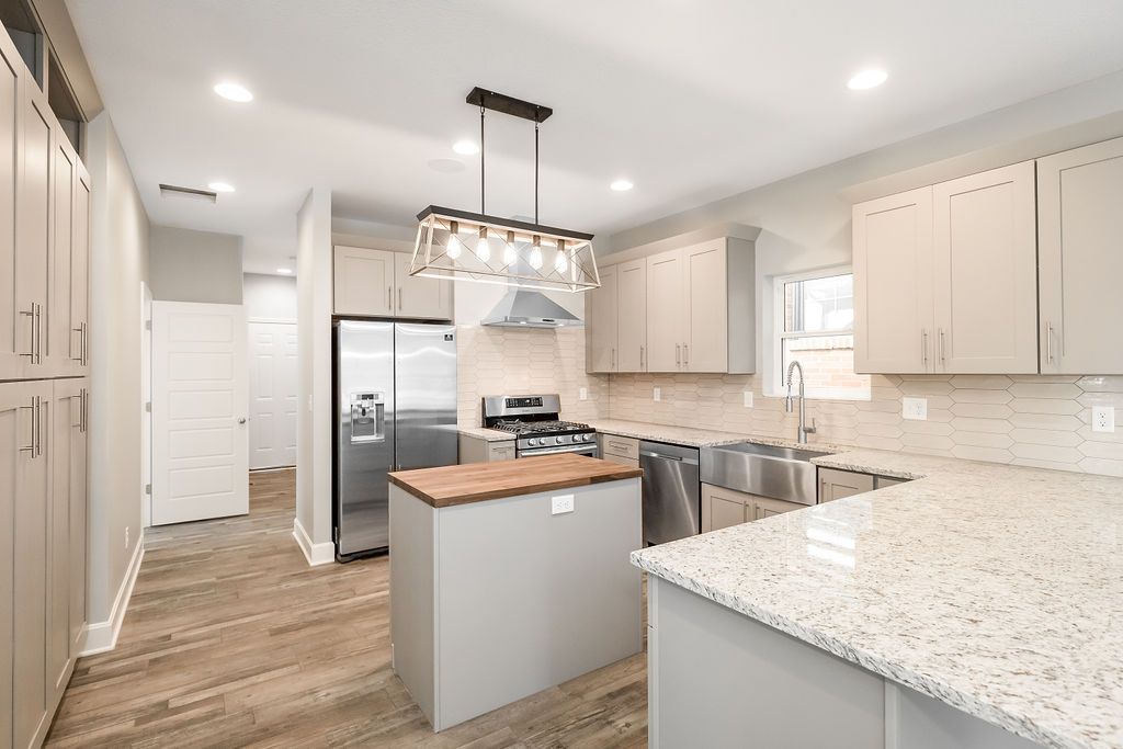 Finished kitchen with quartz counters and custom cabinetry in the Longfellow infill home