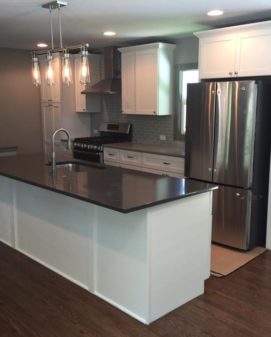Renovated open kitchen with white cabinets and stainless appliances